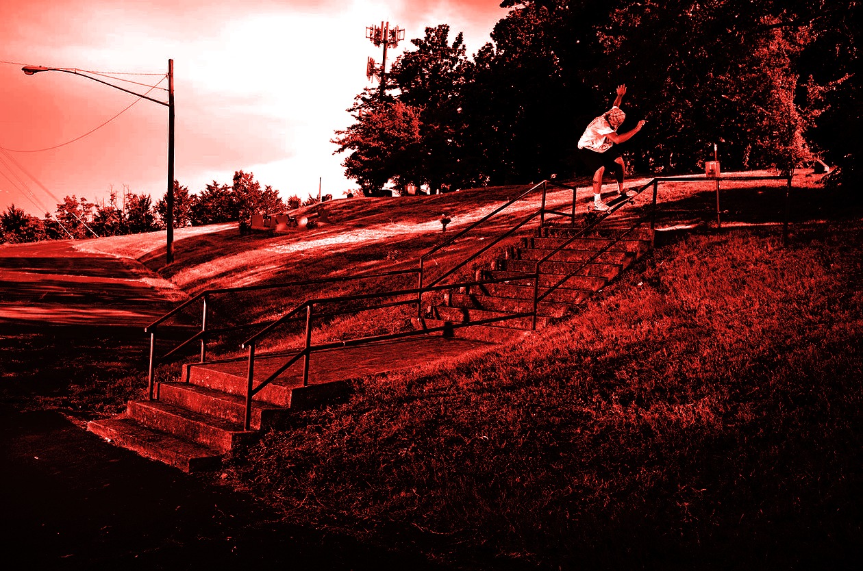 Kyle Walsh boardsliding a handrail, in black, red and white